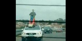 Locura del día: circulando con un tobogán (con persona) en el techo del coche