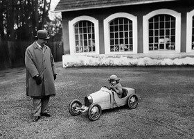 Ettore Bugatti y su hijo menor, Roland, montado en el Baby Type 52.