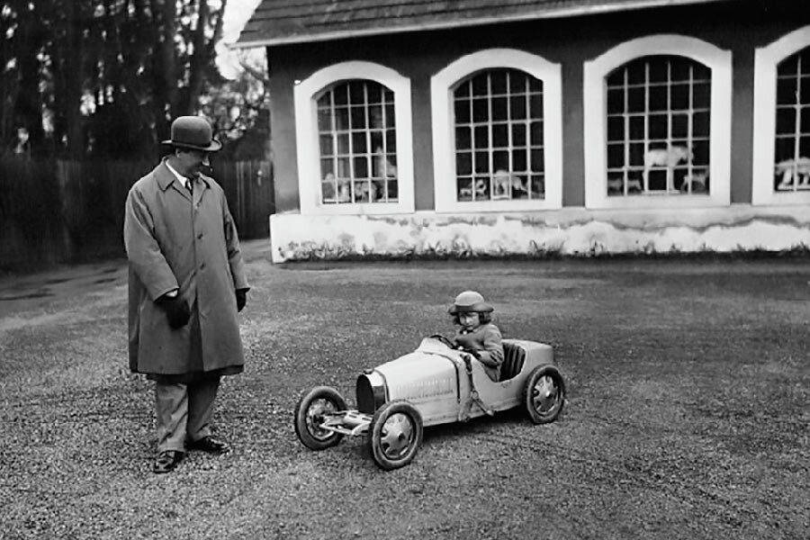 Ettore Bugatti y su hijo menor, Roland, montado en el Baby Type 52.