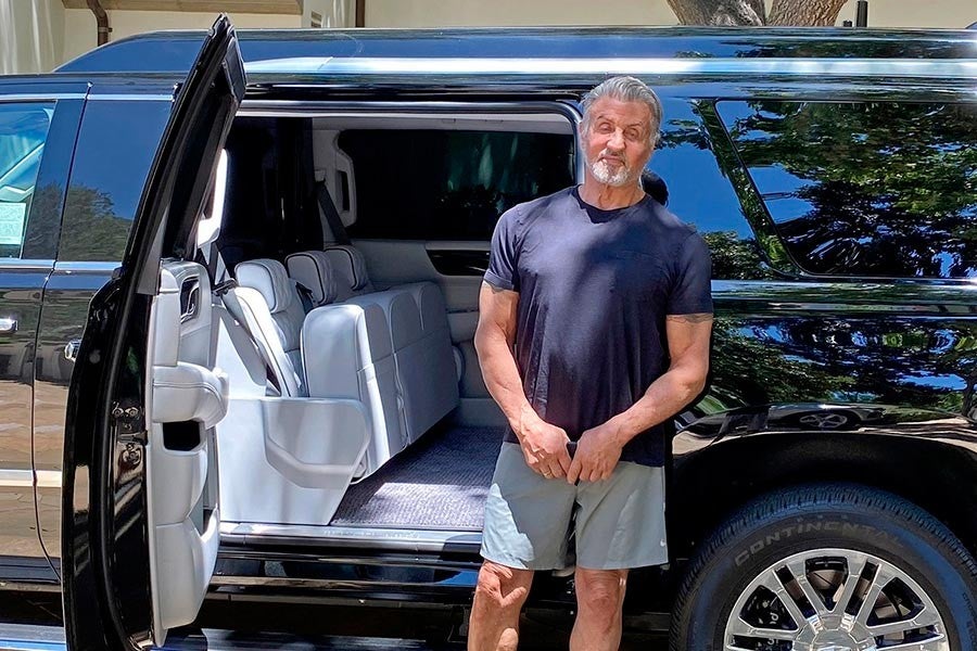 Sylvester Stallone posando junto a su Cadillac Escalade customizado